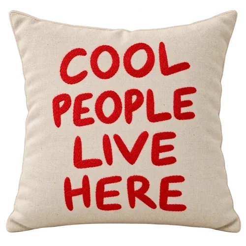 The Cool People Pillow embroidered pillow. COOL PEOPLE LIVE HERE, stitched in red. A welcome mat for the sofa.